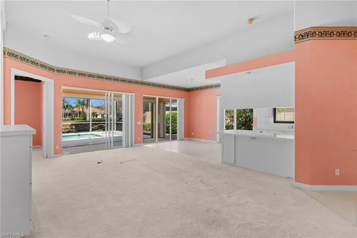 Unfurnished living room with a ceiling fan, plenty of natural light, and light colored carpet