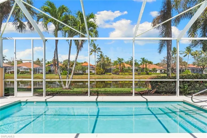 Swimming pool with a lanai, a sunroom, a residential view, and a water view