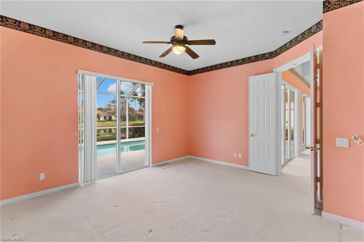 Empty room with a ceiling fan and light colored carpet