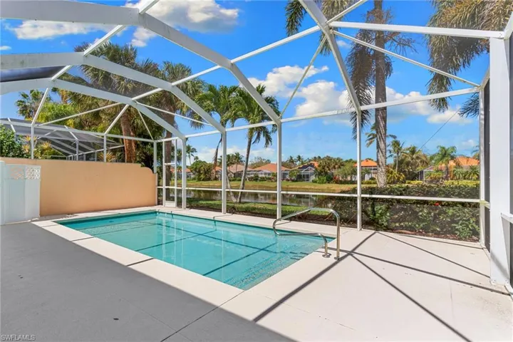 Swimming pool featuring a patio, a sunroom, a lanai, a residential view, and a water view
