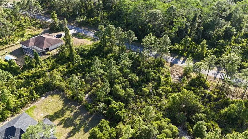 Birds eye view of property featuring a view of trees