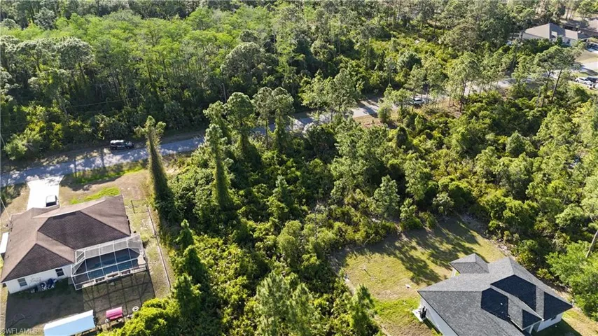 Birds eye view of property with a wooded view