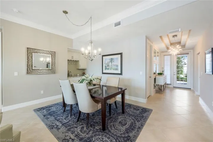 Dining area with a chandelier, crown molding, and light tile patterned floors