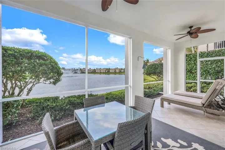 Sunroom / solarium featuring tile patterned floors and a water view