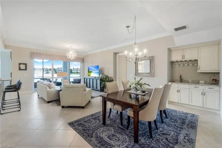 Dining space with a chandelier, crown molding, and light tile patterned floors