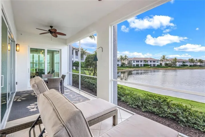 Sunroom with tile patterned flooring and a water view