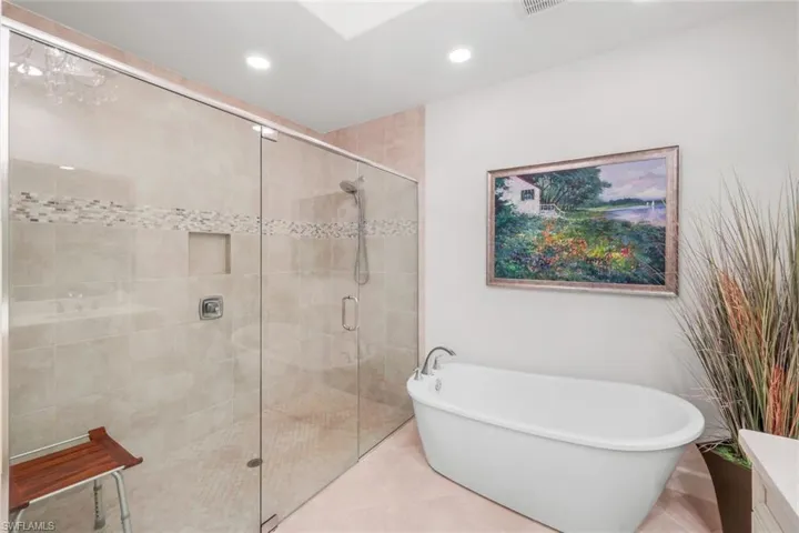 Full bath featuring a freestanding tub, a shower stall, recessed lighting, vanity, and tile patterned flooring