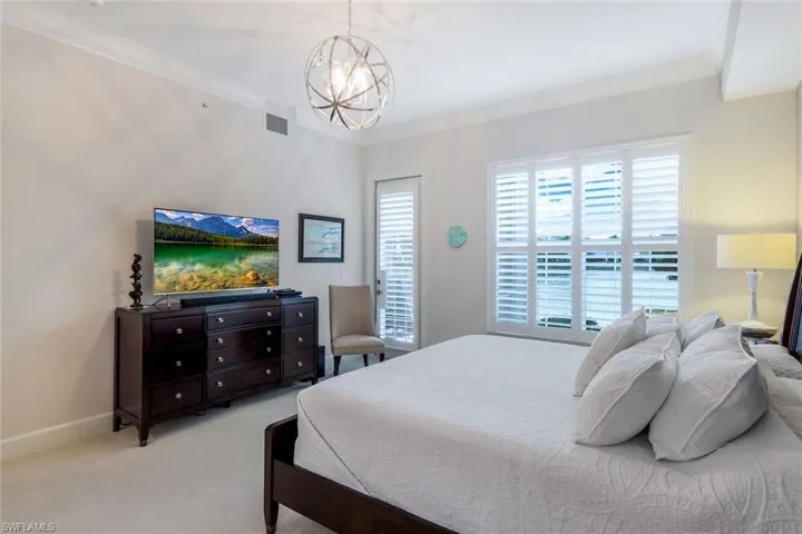 Bedroom featuring ornamental molding, a chandelier, and carpet flooring