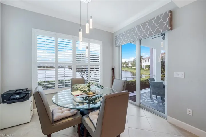 Dining area featuring a water view, ornamental molding, and light tile patterned floors