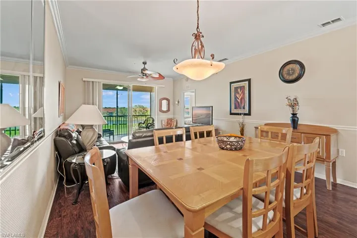 Dining space featuring ornamental molding, ceiling fan, and dark wood-type flooring