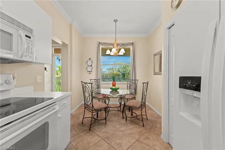 Tiled dining room featuring crown molding and a notable chandelier