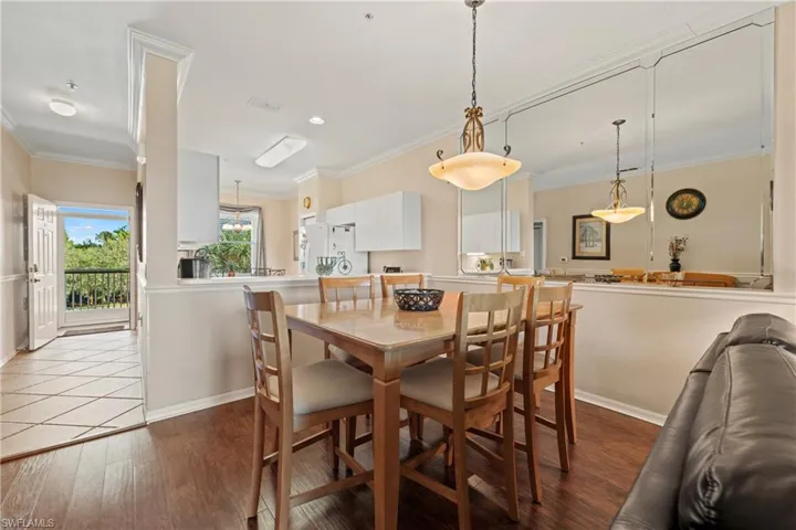 Dining area with light hardwood / wood-style flooring and ornamental molding