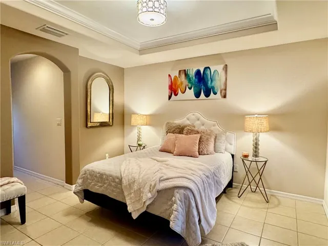Tiled bedroom with a tray ceiling