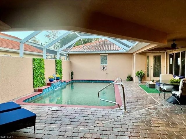 View of swimming pool with ceiling fan, a lanai, and a patio