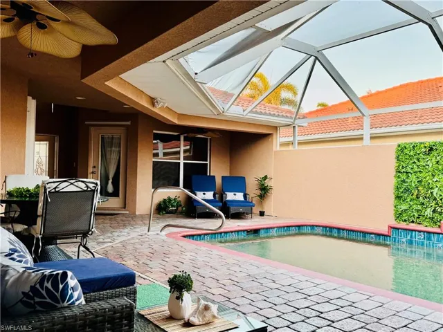 View of swimming pool featuring a lanai, ceiling fan, and a patio