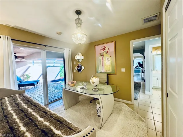 Tiled home office featuring an inviting chandelier