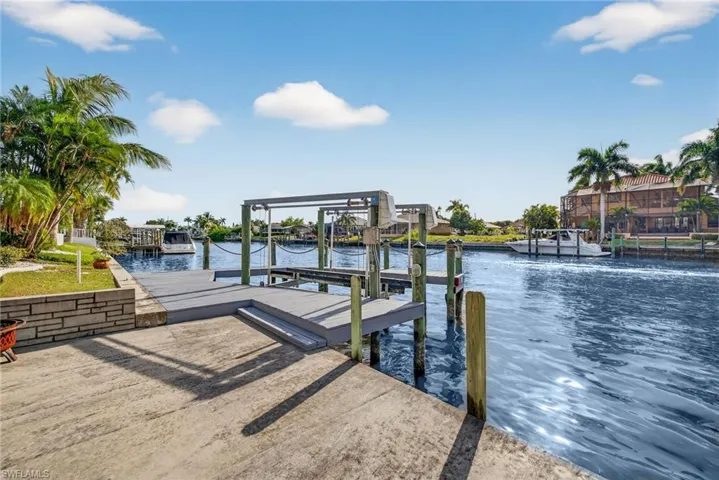 Dock area featuring boat lift and a water view