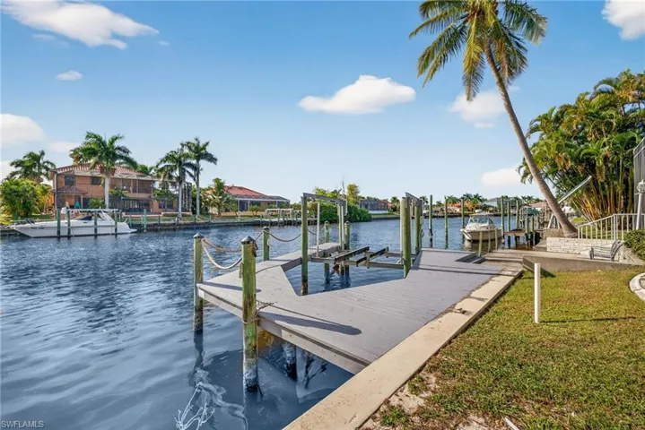 Dock featuring boat lift and a water view