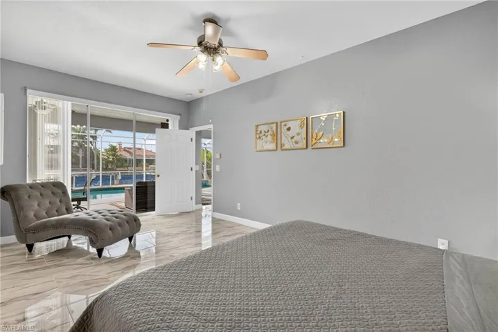 Bedroom featuring light marble finish floors, access to exterior, and a ceiling fan
