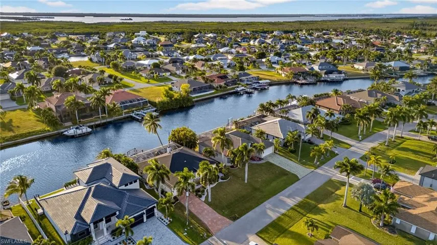 Aerial perspective of suburban area featuring a nearby body of water