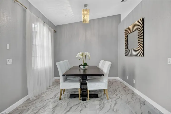 Dining space with light marble finish flooring and baseboards