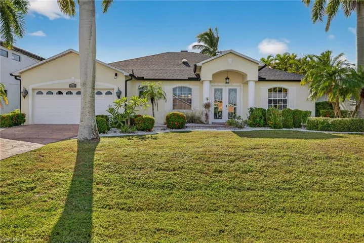 Ranch-style home featuring a front yard, stucco siding, and roof with shingles