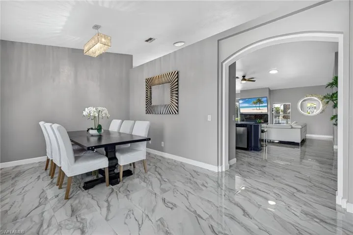 Dining room with light marble finish flooring, ceiling fan, and recessed lighting