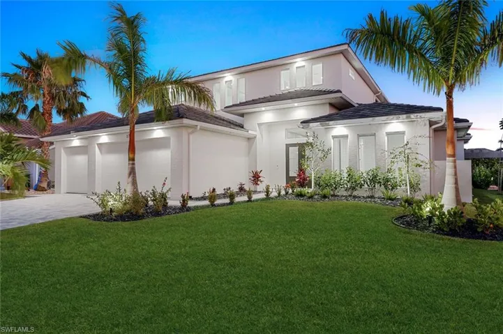 View of front of property featuring a front yard and a garage