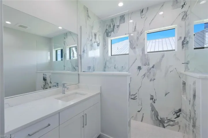 Bathroom with tiled shower and large vanity