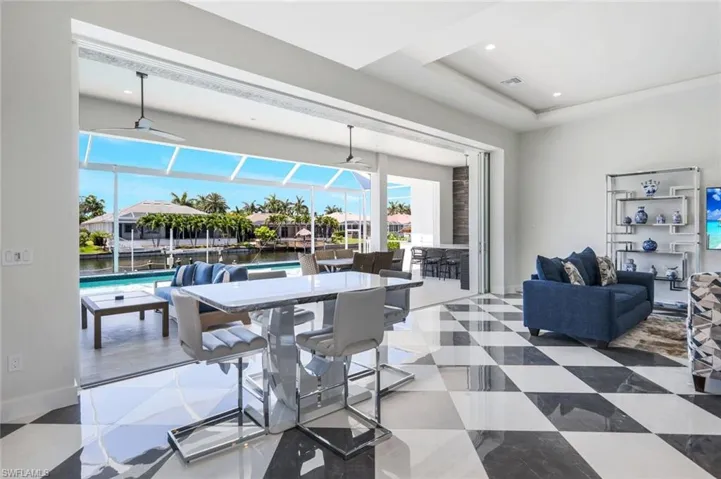 Dining room featuring tile floors, plenty of natural light, ceiling fan, and a raised ceiling