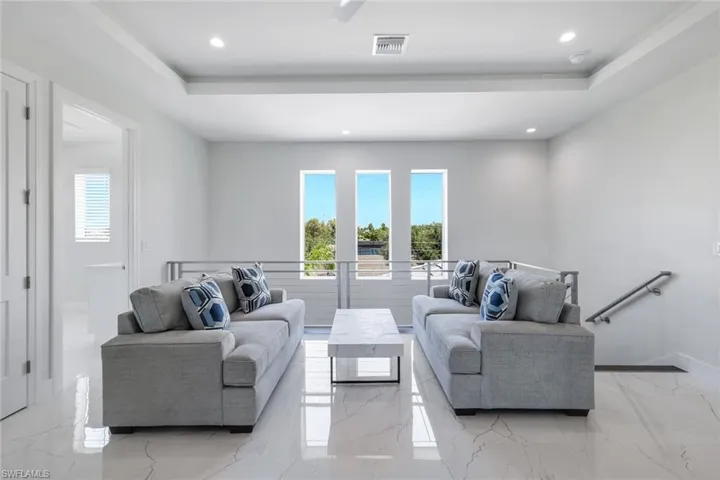 Tiled living room featuring a tray ceiling