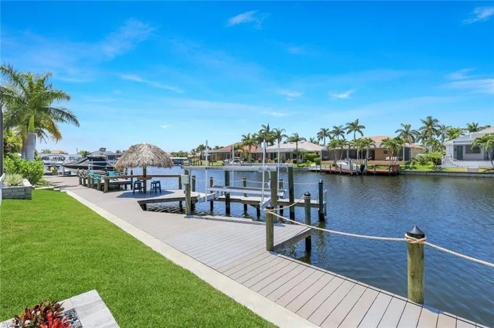 Dock area with a water view and a lawn