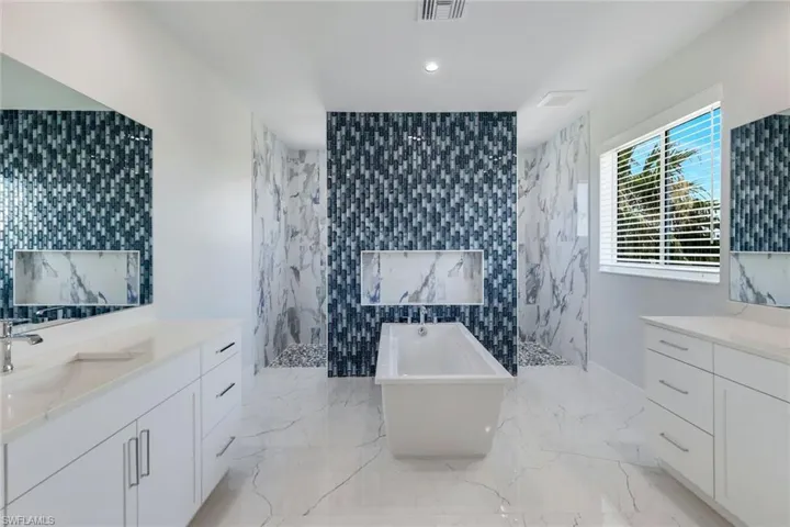 Bathroom with shower with separate bathtub, vanity with extensive cabinet space, tile walls, and tile floors