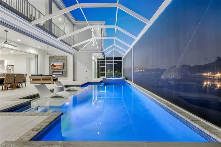View of swimming pool featuring a patio area, a lanai, and ceiling fan