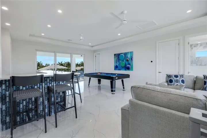 Game room with a raised ceiling, billiards, ceiling fan, and light tile flooring