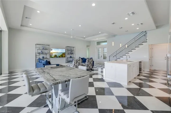 Dining area featuring sink, a tray ceiling, and light tile flooring