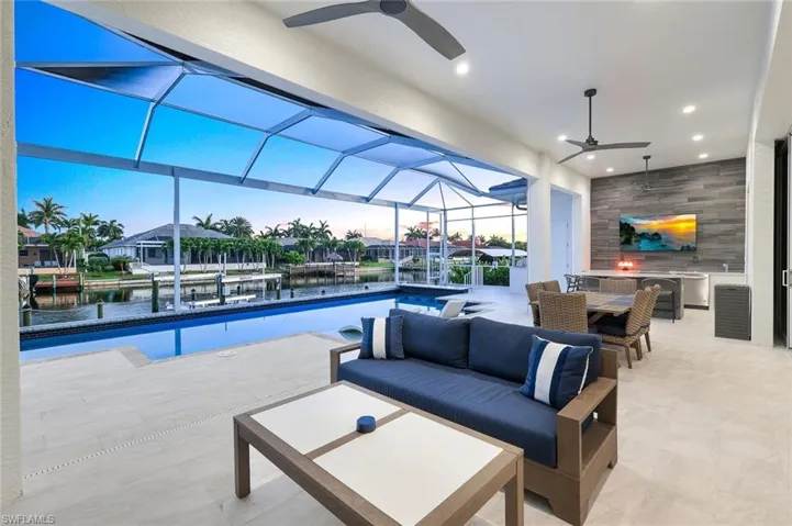View of pool with ceiling fan and a water view