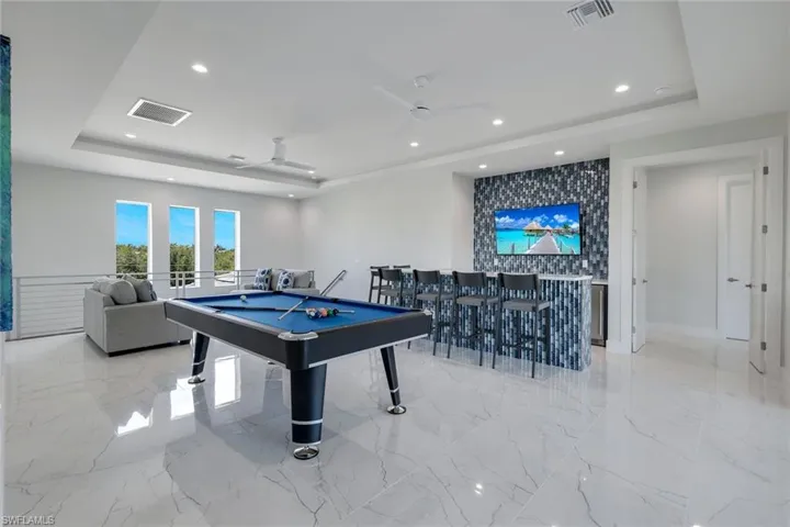 Rec room featuring billiards, a raised ceiling, ceiling fan, and light tile floors