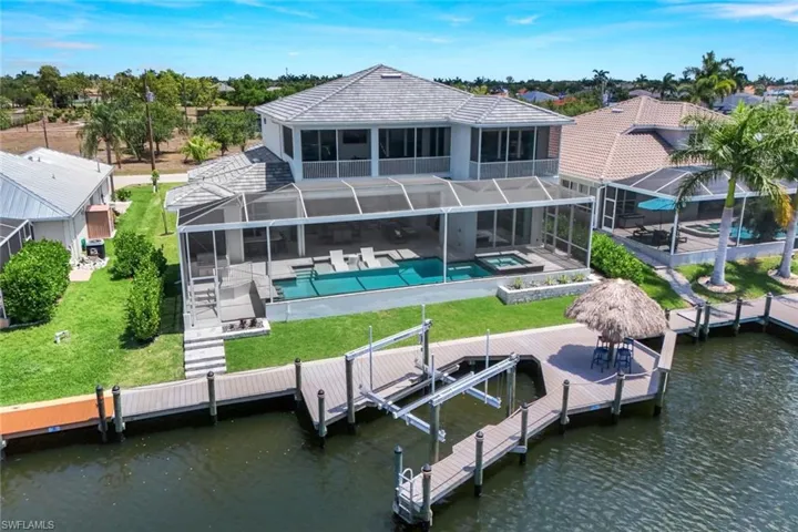 Rear view of house with a patio, a lanai, and a water view