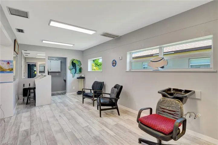 Living area with baseboards, visible vents, and wood finished floors