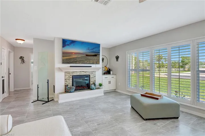 Living room featuring plenty of natural light, baseboards, and a glass covered fireplace