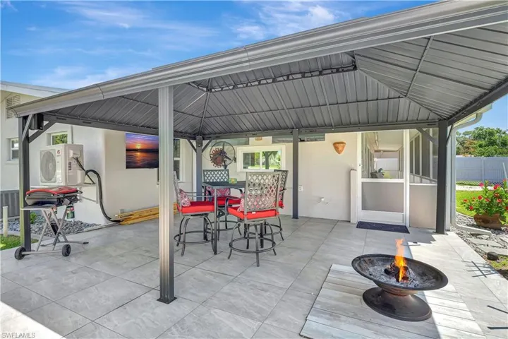 View of patio / terrace with an outdoor fire pit, a gazebo, outdoor dining space, and fence