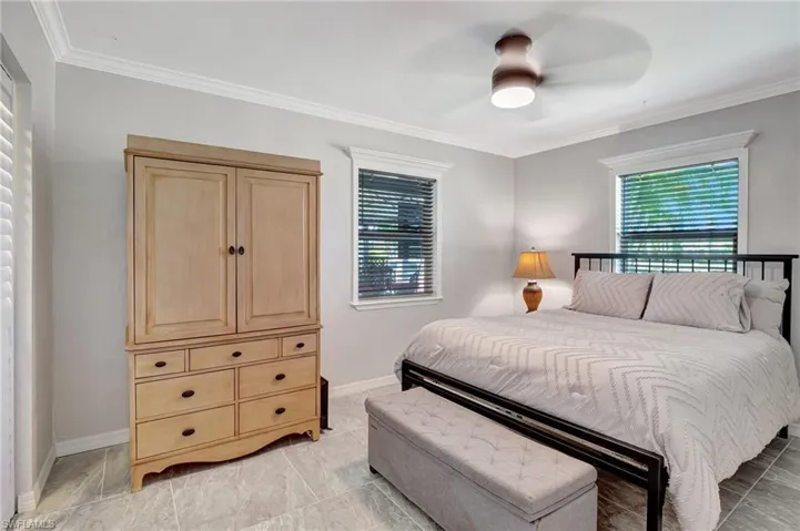 Bedroom featuring baseboards, crown molding, and ceiling fan
