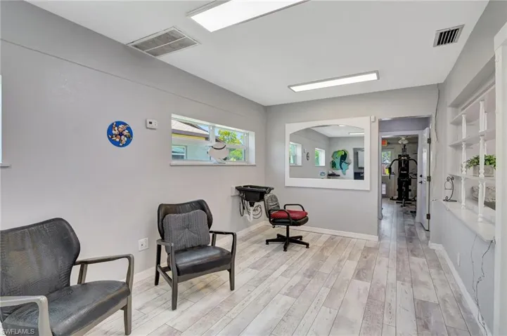 Living area featuring baseboards, arched walkways, visible vents, and light wood-type flooring