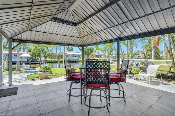 View of patio / terrace featuring outdoor dining area, a water view, and a gazebo