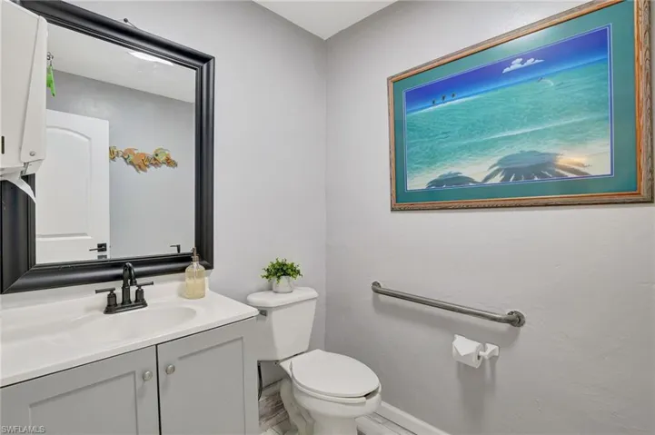Half bath with baseboards, toilet, and vanity