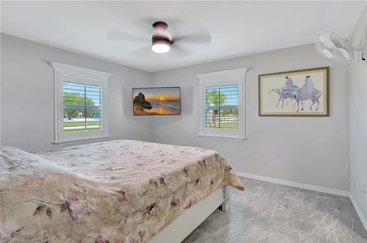 Bedroom featuring baseboards, multiple windows, and a ceiling fan