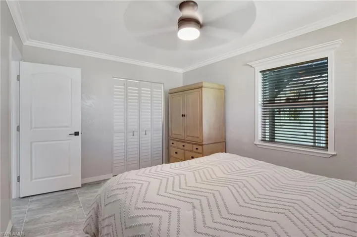 Bedroom featuring ornamental molding, a closet, and ceiling fan