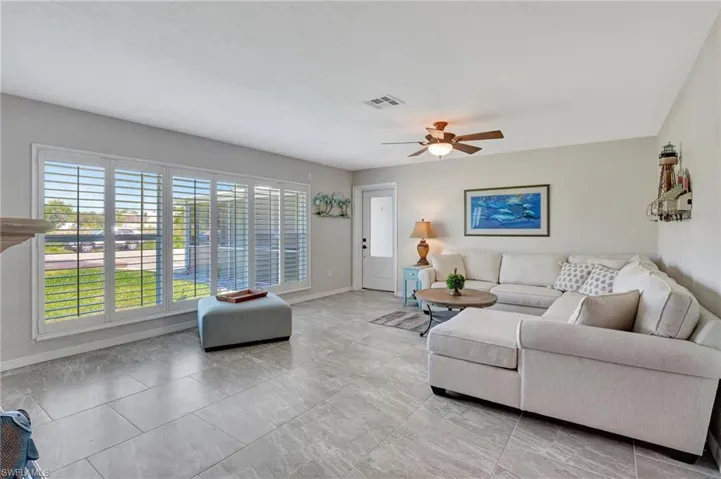 Living area featuring baseboards, visible vents, and a ceiling fan
