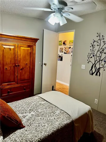 Bedroom with a textured ceiling and a ceiling fan
